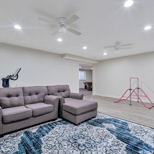 Living room featuring light hardwood floors and ceiling fan