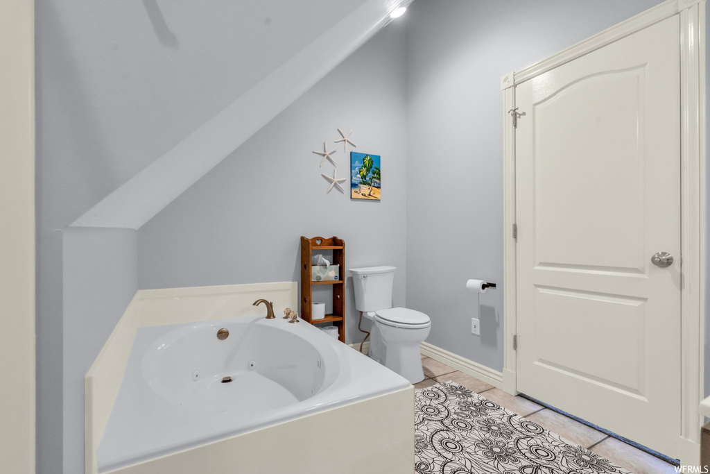 Bathroom with light tile flooring and a bath