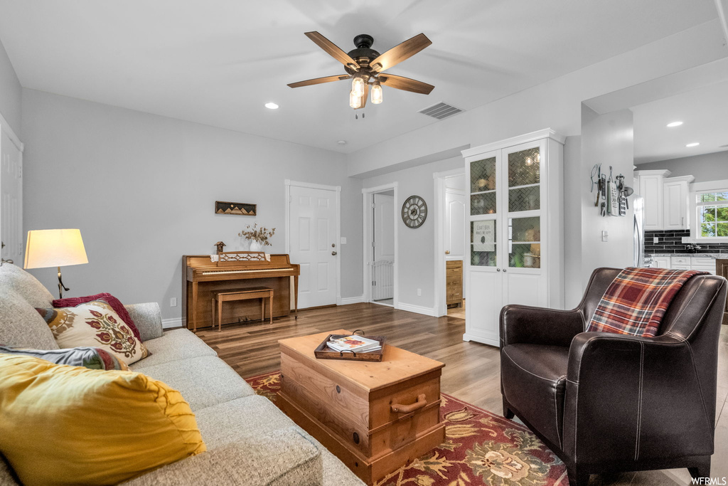 Living room featuring ceiling fan and hardwood floors