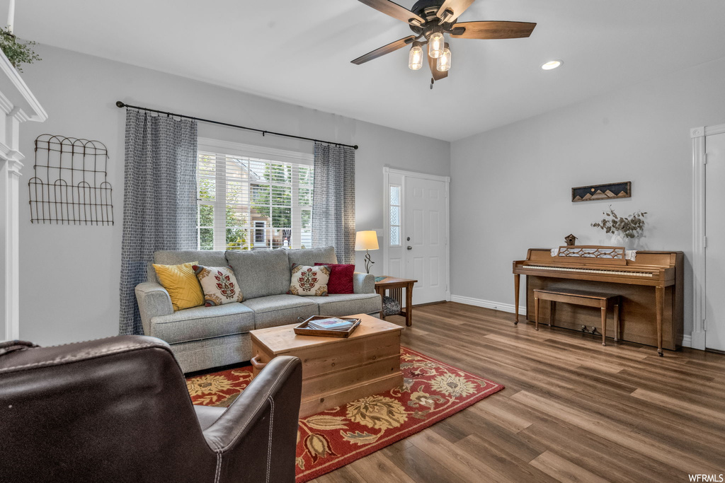 Living room featuring ceiling fan and hardwood flooring