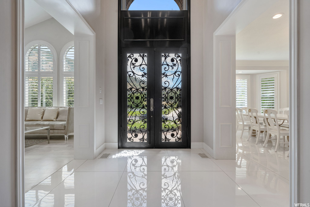Entrance foyer with light tile floors and french doors