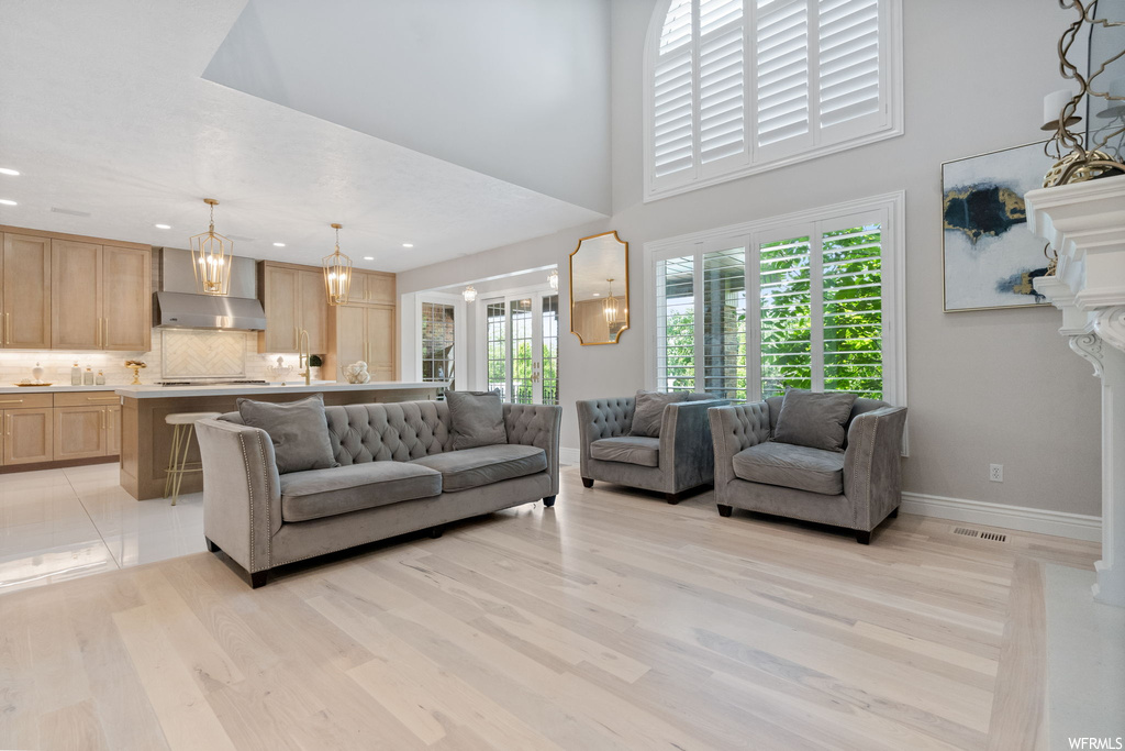 Hardwood floored living room with a high ceiling and plenty of natural light