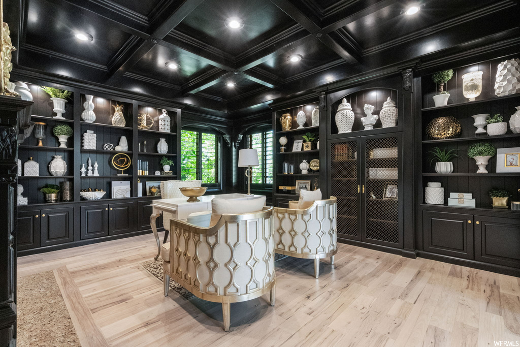 Office featuring light hardwood flooring, built in shelves, beamed ceiling, coffered ceiling, and crown molding