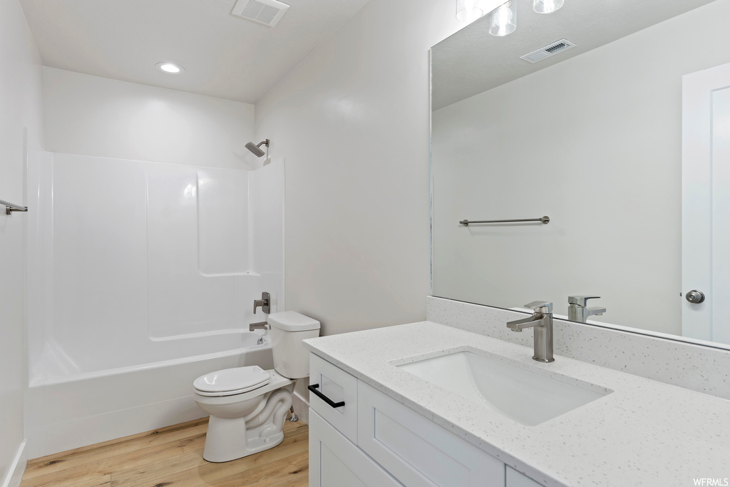 Full bathroom featuring bathtub / shower combination, light hardwood flooring, vanity, and mirror