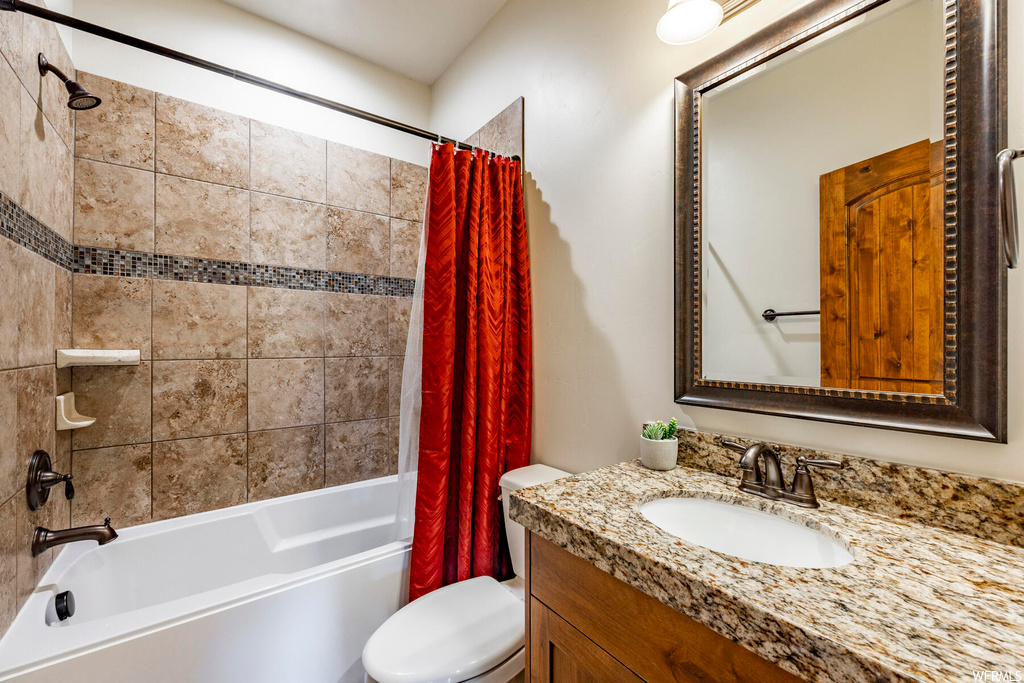 Full bathroom featuring mirror, large vanity, and shower / bath combination with curtain