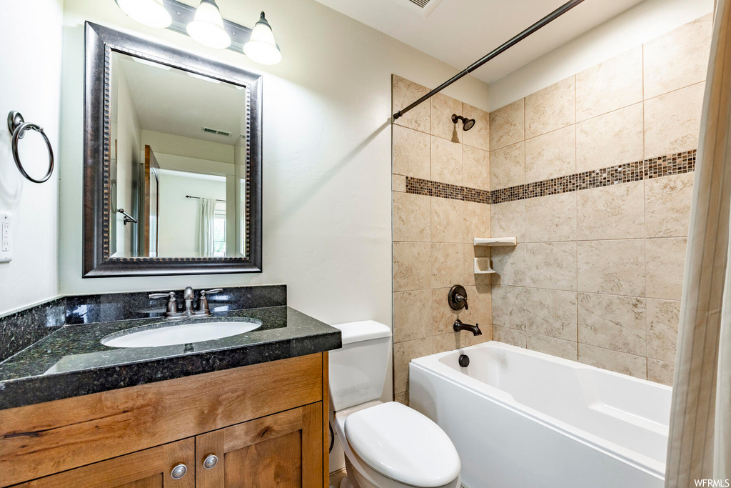 Full bathroom featuring mirror, vanity, and tiled shower / bath combo