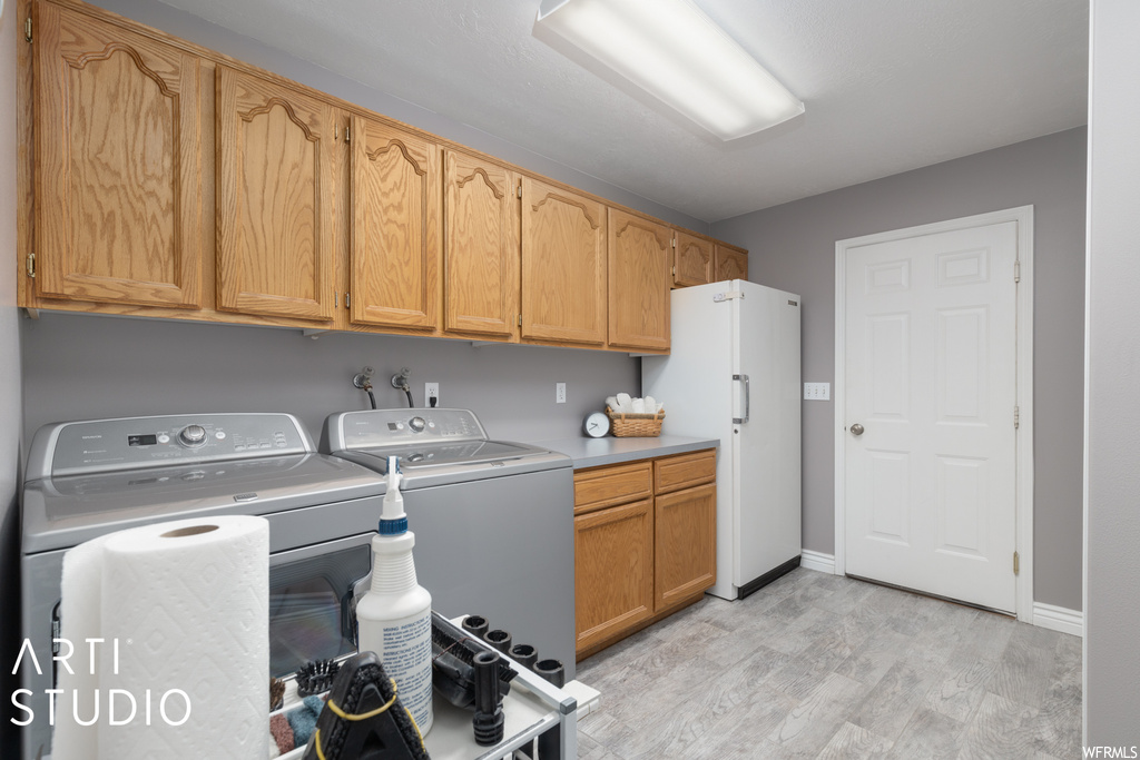 Laundry room featuring light parquet floors and washing machine and dryer