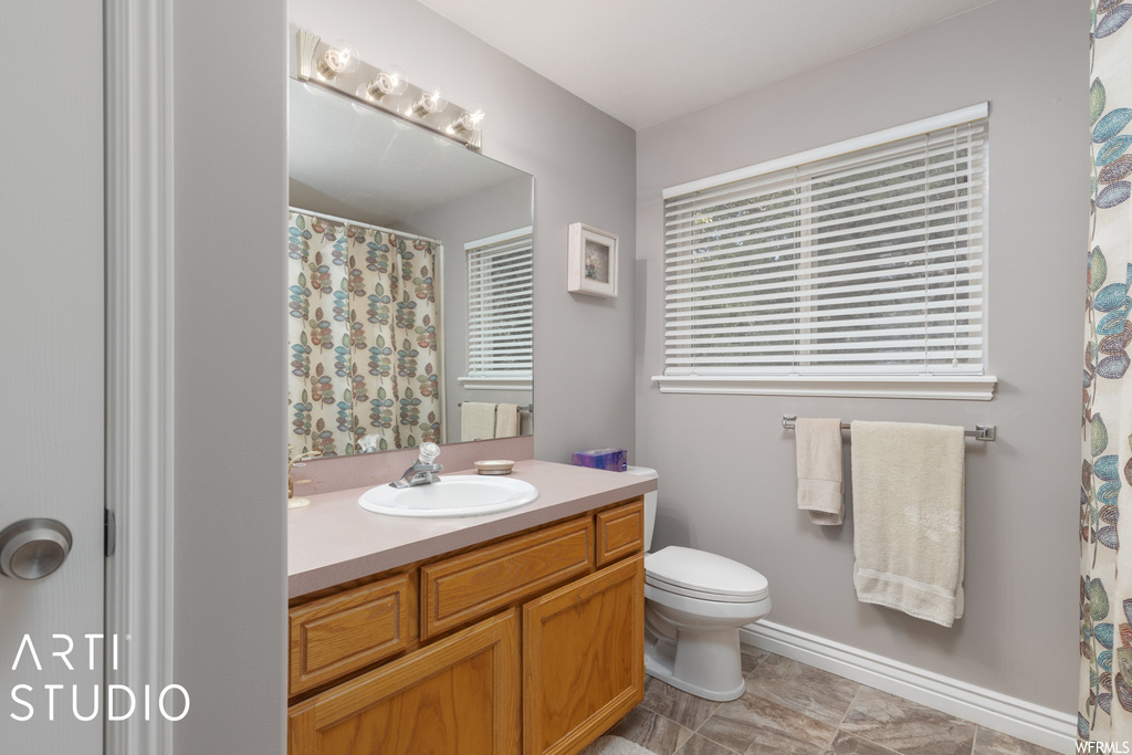 Bathroom featuring tile flooring, vanity, and mirror