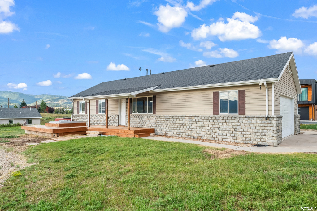 Single story home featuring a mountain view and a front yard