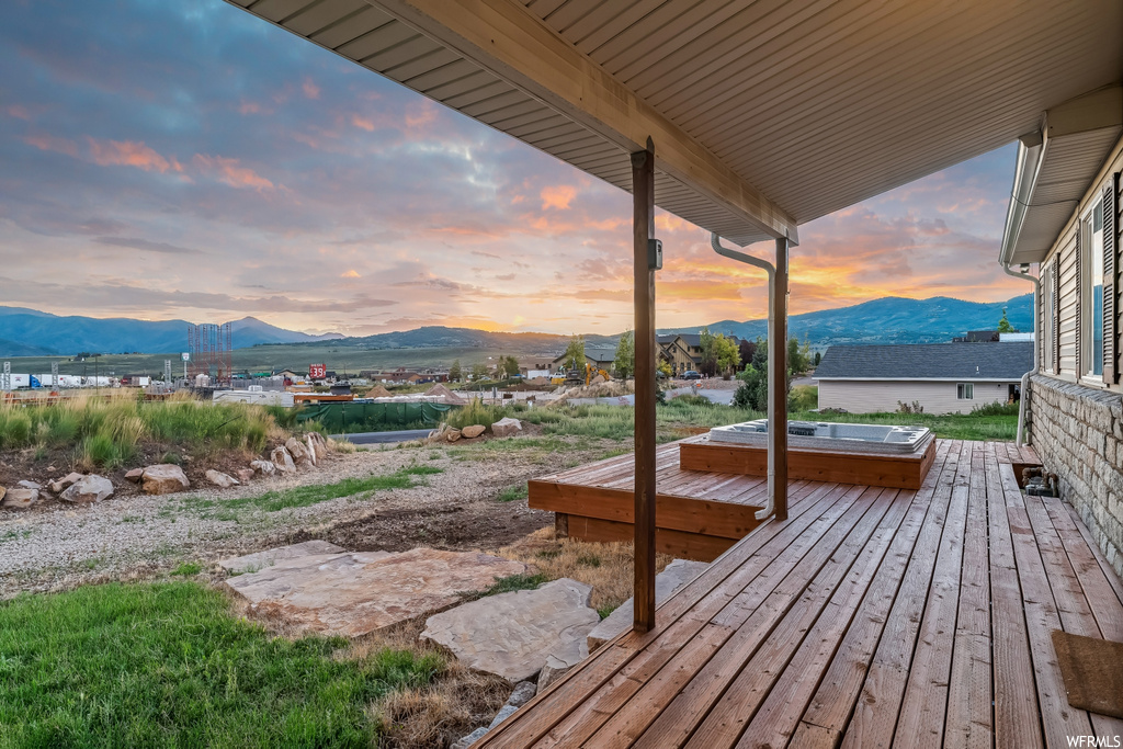 Deck at dusk featuring a mountain view