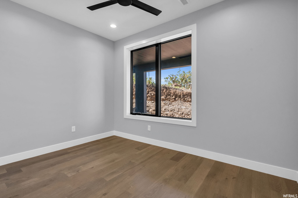 Empty room with ceiling fan and hardwood / wood-style floors