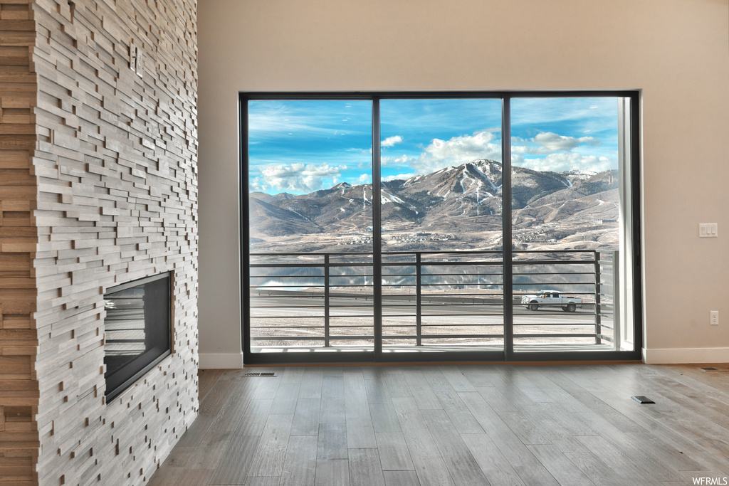 Unfurnished living room with a fireplace, light hardwood / wood-style flooring, and a mountain view