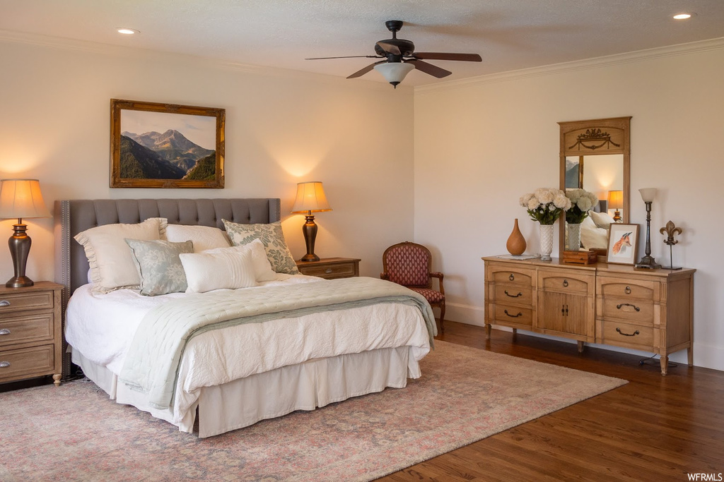 Bedroom featuring ceiling fan, light hardwood floors, and ornamental molding