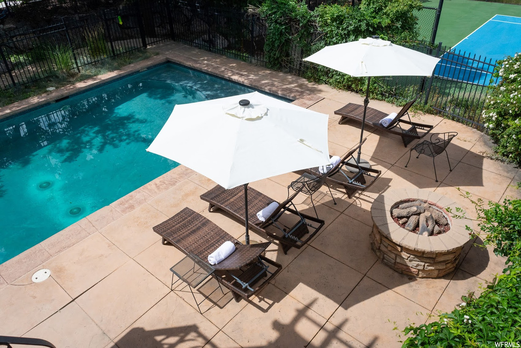 View of pool featuring a firepit and a patio area