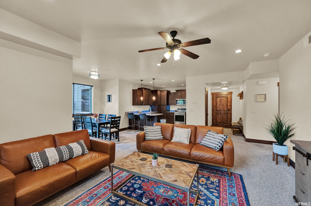 Living room featuring carpet floors and ceiling fan