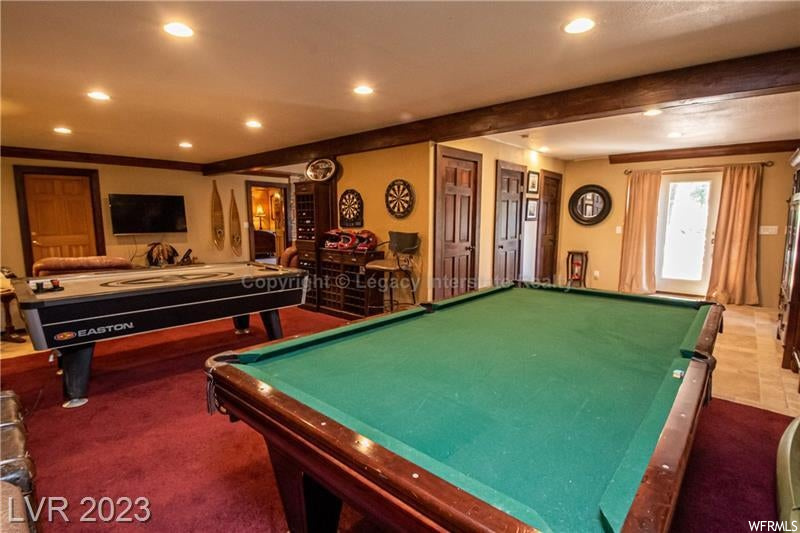 Game room featuring ornamental molding, beamed ceiling, and carpet flooring