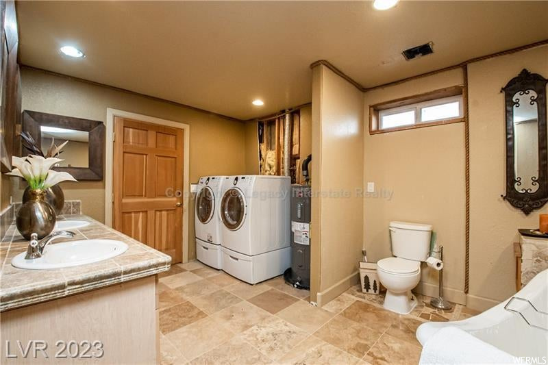 Clothes washing area featuring separate washer and dryer and light tile flooring