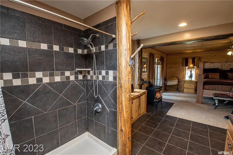 Bathroom with wood walls, tiled shower, and vanity