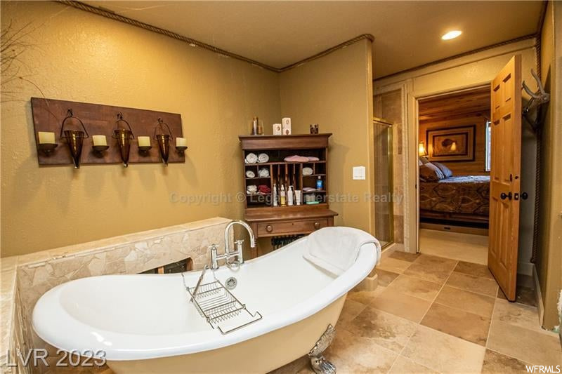 Bathroom with independent shower and bath and light tile floors