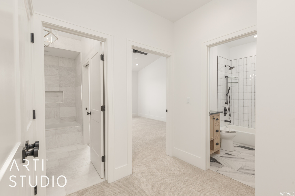 Bathroom with tiled shower / bath combo and light tile floors