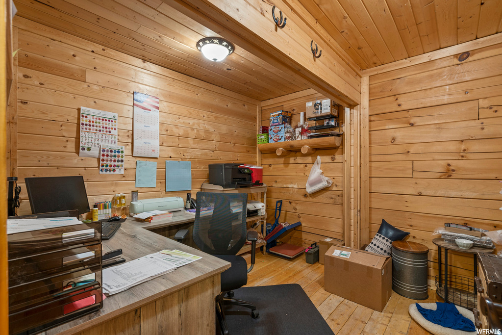 Home office with light hardwood floors, wooden walls, and wood ceiling