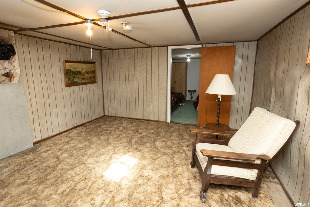 Living area featuring light carpet and wooden walls