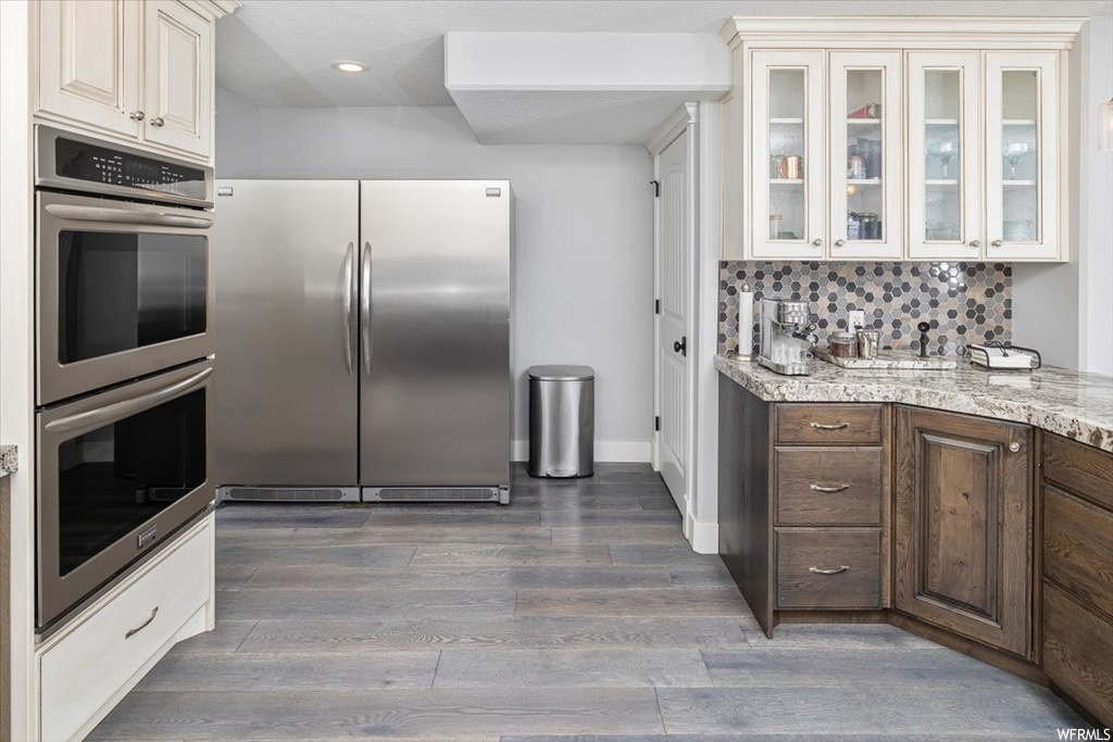 Kitchen featuring backsplash, stainless steel appliances, and light hardwood flooring