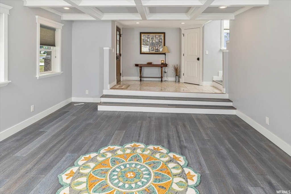 Living room with coffered ceiling, light parquet floors, and beamed ceiling