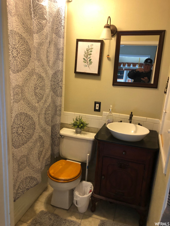 Bathroom with mirror, tile floors, vanity, and backsplash