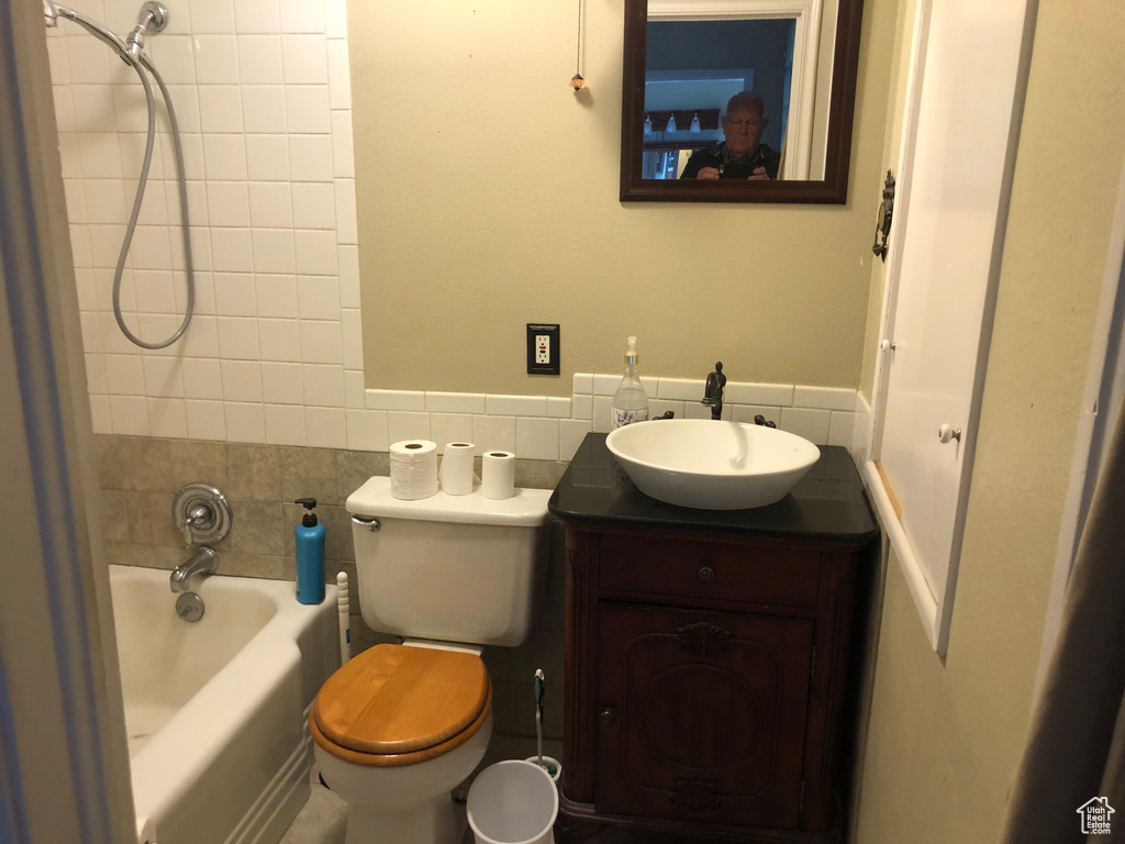 Full bathroom featuring tiled shower / bath, tasteful backsplash, toilet, and vanity