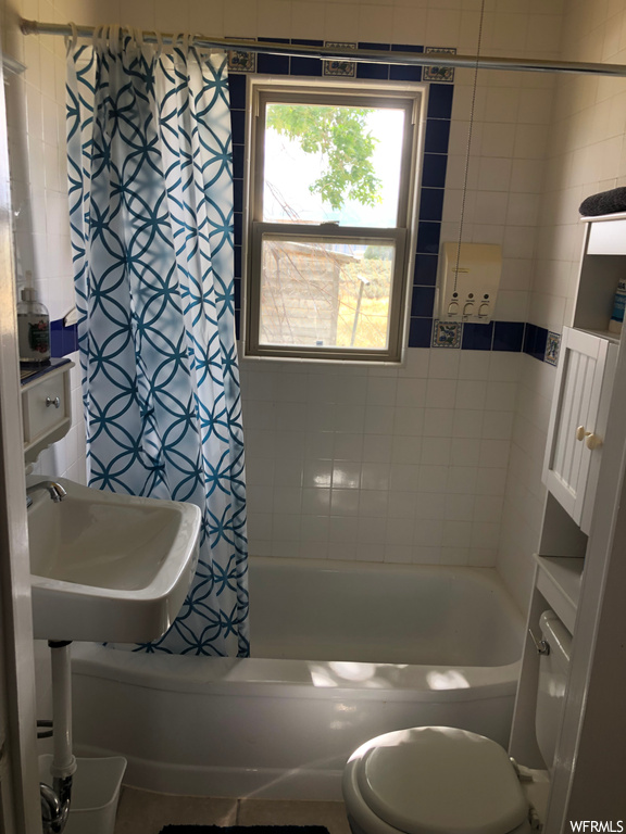 Full bathroom featuring sink and shower / bath combination with curtain