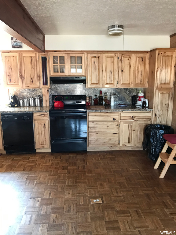 Kitchen with a textured ceiling, backsplash, range, black dishwasher, and parquet flooring
