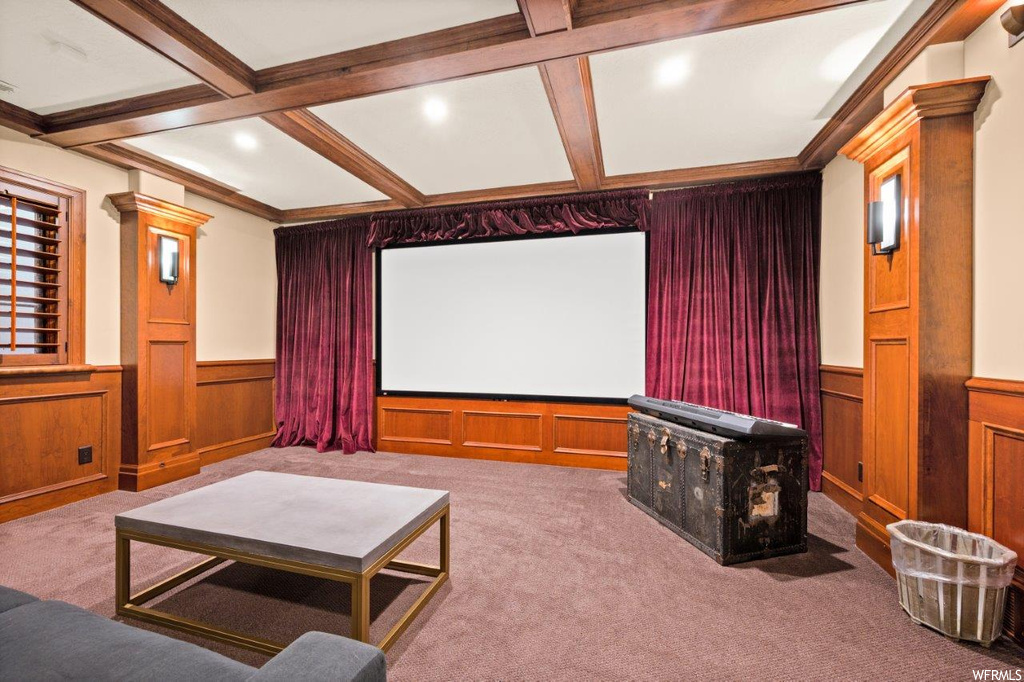 Carpeted home theater room featuring beamed ceiling and coffered ceiling