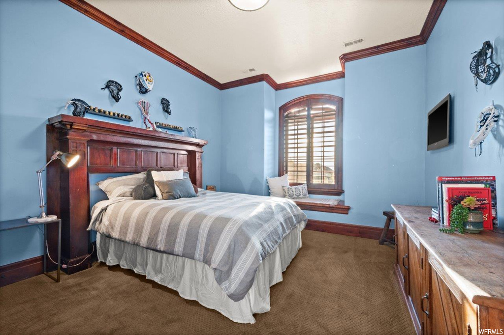 Carpeted bedroom with crown molding