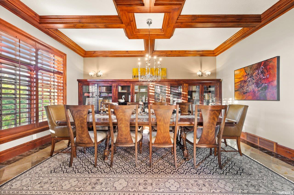 Tiled dining area featuring beamed ceiling, coffered ceiling, and ornamental molding