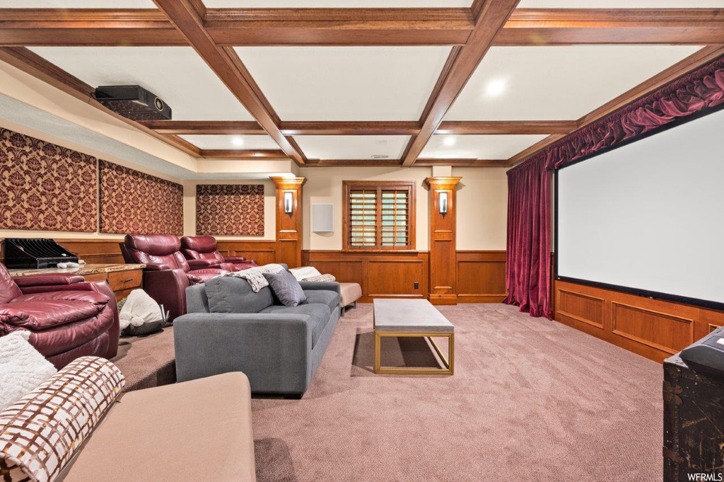 Carpeted home theater featuring coffered ceiling and beamed ceiling