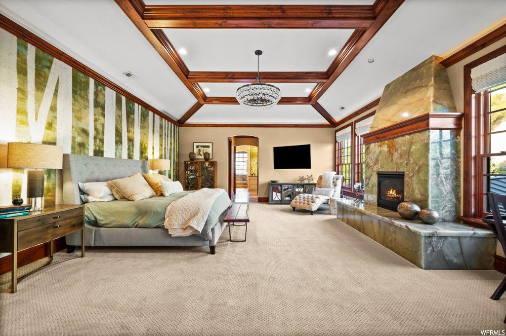 Carpeted bedroom featuring ornamental molding, coffered ceiling, and a fireplace