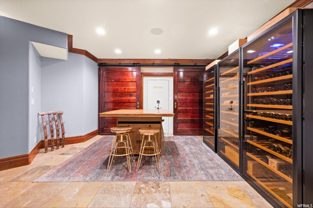 Wine cellar with crown molding and tile floors