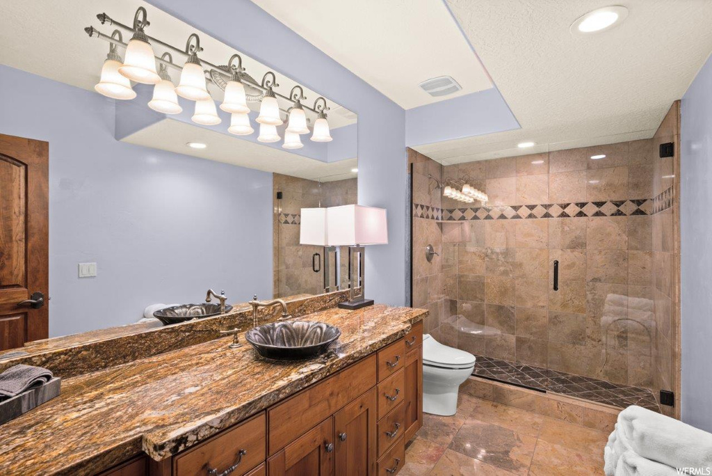 Bathroom with vanity, tile floors, mirror, and an enclosed shower
