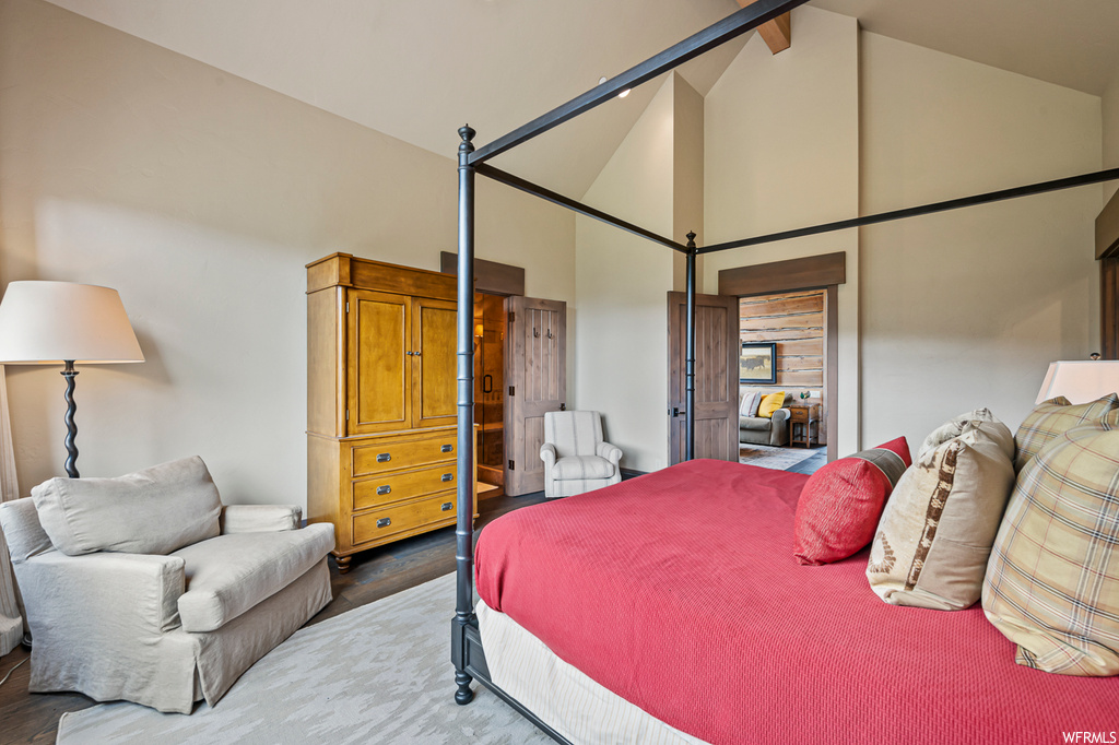Bedroom with a high ceiling, light hardwood floors, and lofted ceiling