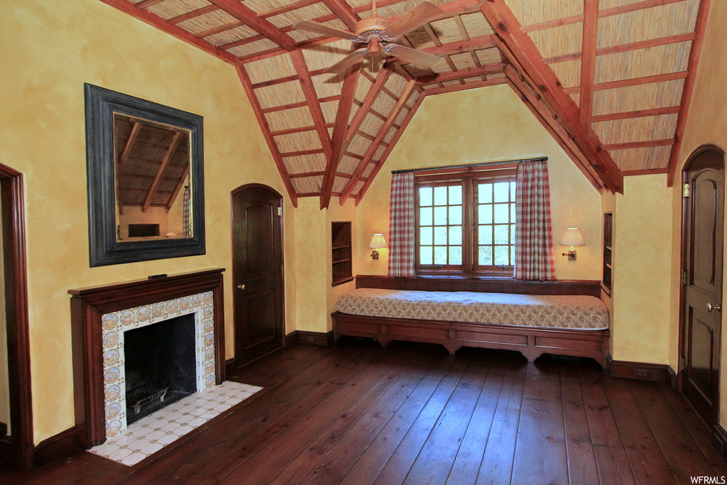 Interior space featuring lofted ceiling with beams, dark hardwood floors, and ceiling fan