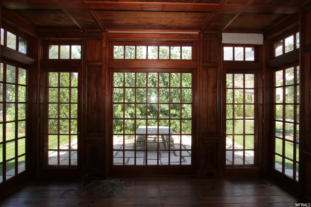 Entryway featuring dark hardwood flooring and wood ceiling