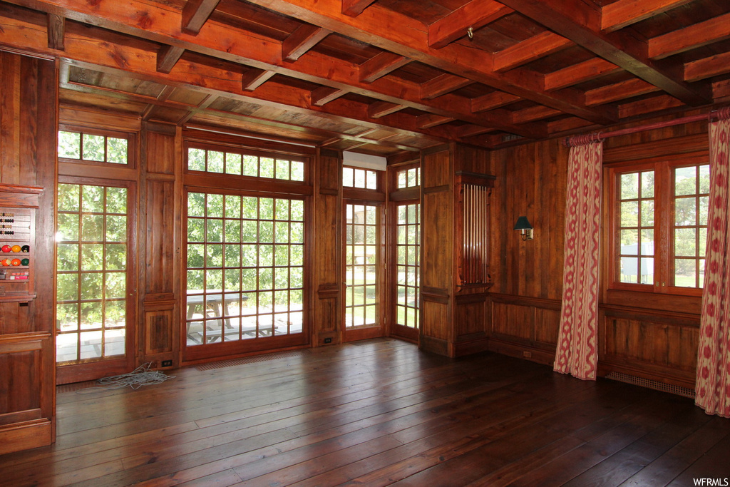 Spare room with beamed ceiling, wooden ceiling, wood walls, dark parquet floors, and coffered ceiling