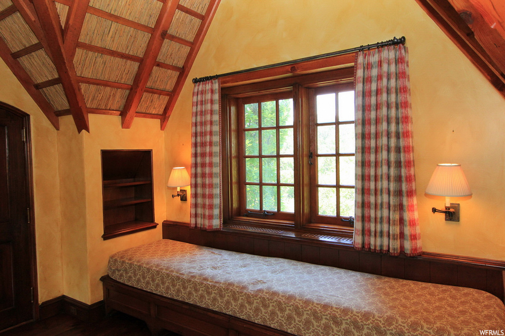 Bedroom with vaulted ceiling with beams and wooden ceiling