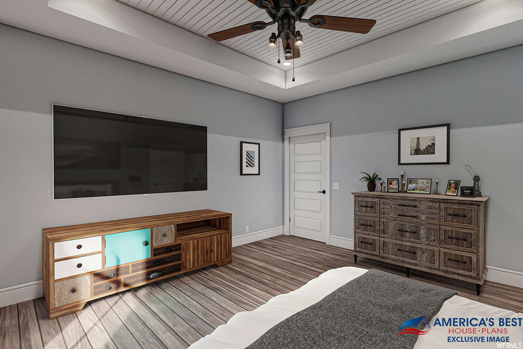 Hardwood floored bedroom with a raised ceiling, ceiling fan, and wooden ceiling