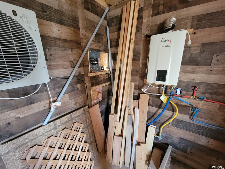 Interior space featuring tankless water heater and wooden walls