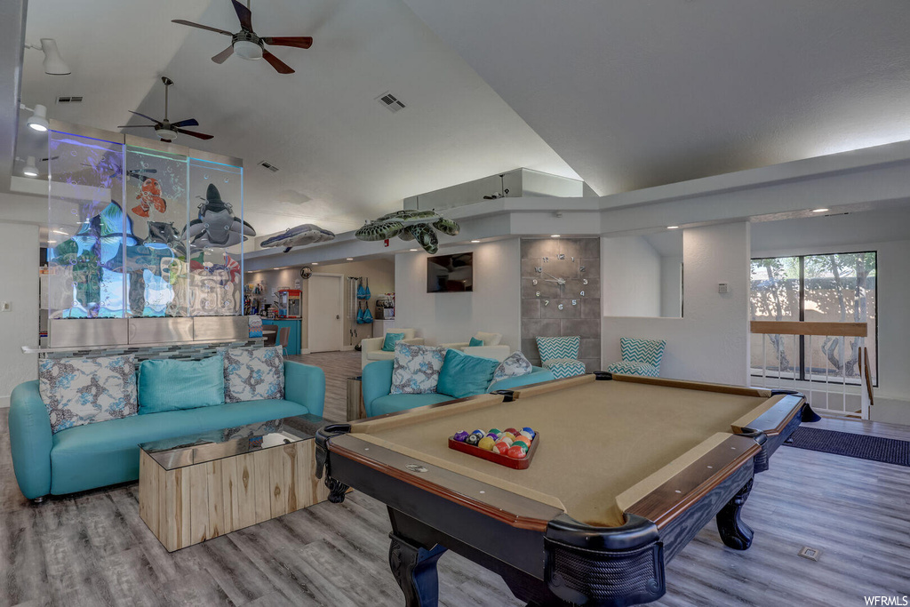 Playroom with lofted ceiling, a high ceiling, light hardwood flooring, and ceiling fan