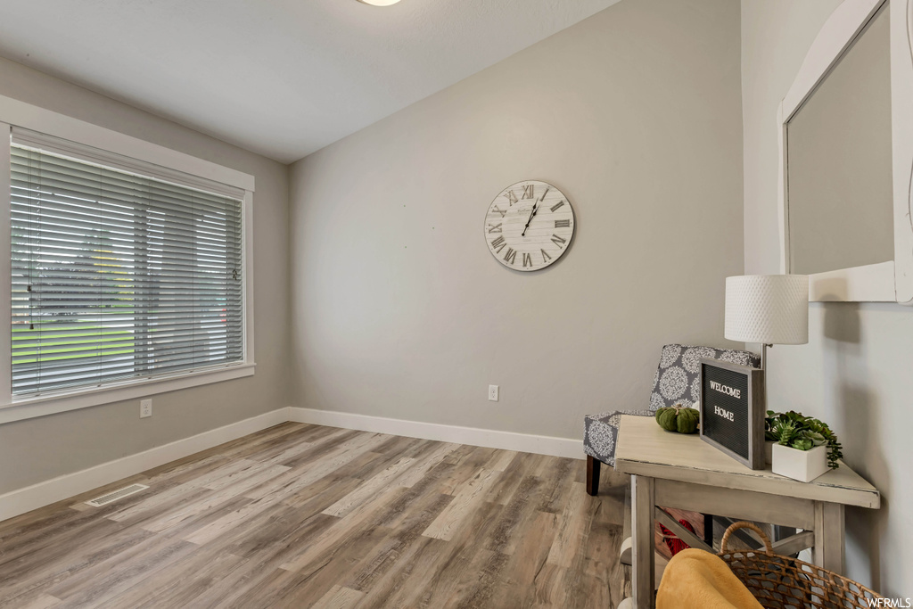 Hardwood floored office space with lofted ceiling