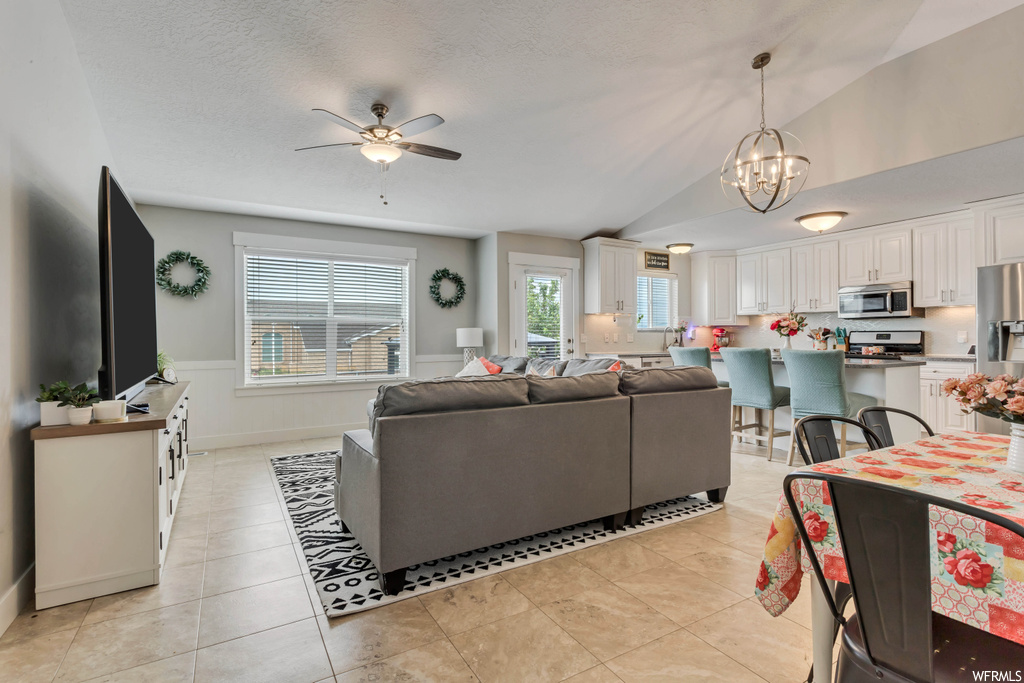 Tiled living room with lofted ceiling and ceiling fan