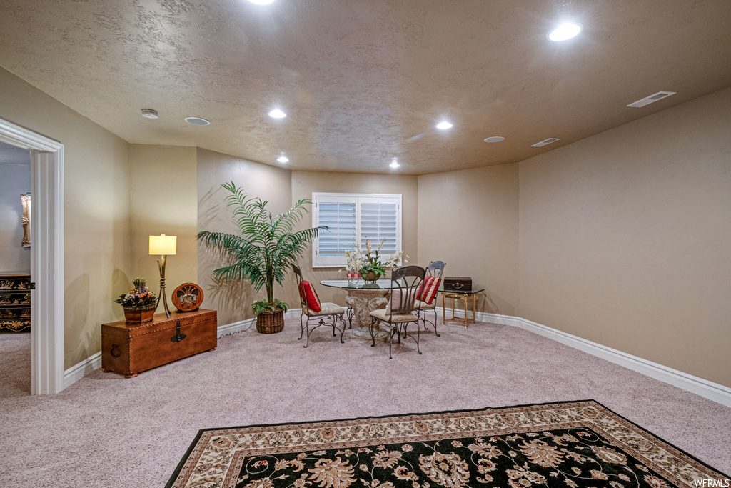 Dining area featuring light carpet and a textured ceiling